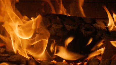 Close-up shot of warm cozy burning fire in a brick fireplace. Slow motion. HD