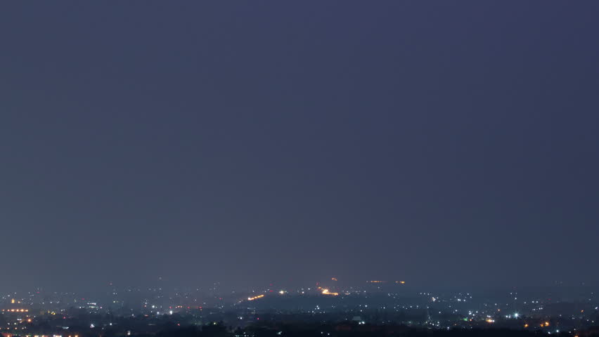 Lightning storm over city in purple light
