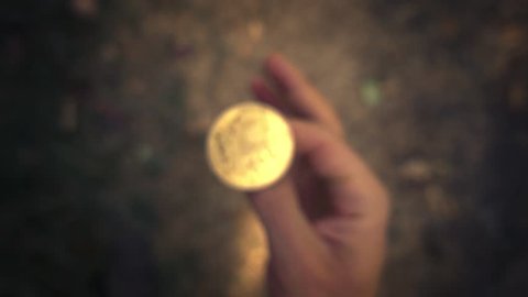 Hand flipping golden bitcoin coin and failing to catch it. Slow motion, closeup.