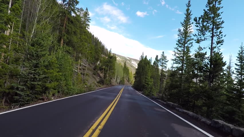 Rocky Mountain National Park forest road POV. Rocky Mountain National Park located northwest of Denver on the Continental Divide. Mountains, alpine lakes, tundra, forests and wildlife. Royalty-Free Stock Footage #33807634