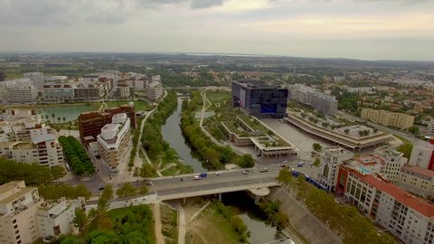 Aerial shot circling slowly over the River Lez in urban Montpellier