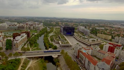 Slow aerial shot circling above the River Lez in urban Montpellier
