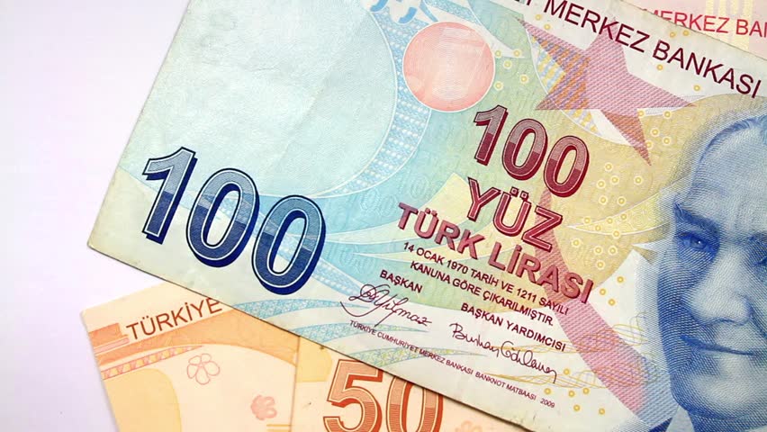 Turkish banknotes. Camera pans left to right over Turkish money pile. 
