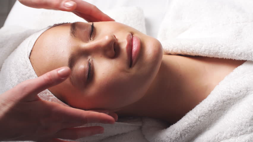 Spa woman facial Massage. Face Massage in beauty spa salon. Female enjoying relaxing face massage in cosmetology spa centre. Body care, skin care, wellness, beauty treatment. Royalty-Free Stock Footage #33818251