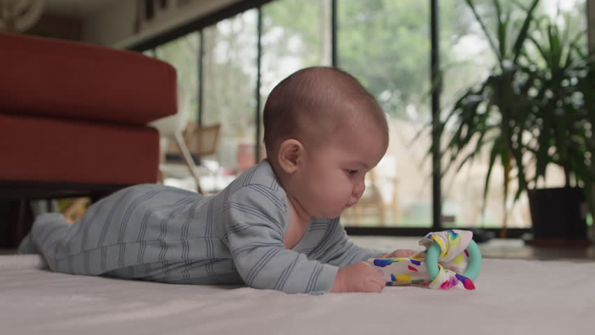 Baby on tummy time playing with toys