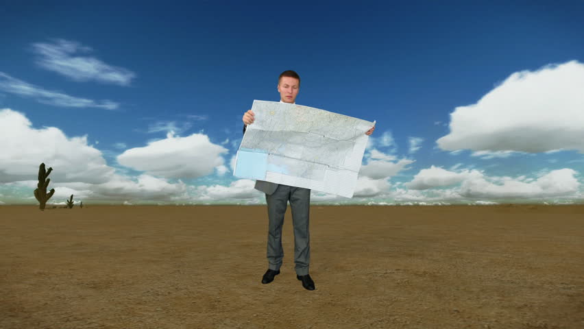 Businessman with Map in Desert with Time Lapse Clouds
