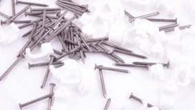 White plastic staples with nails for fixing wires