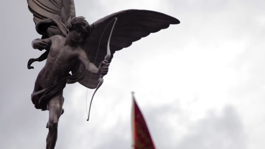 A stationary close-up shot of Eros statue on Piccadilly Circus in London. A flag
