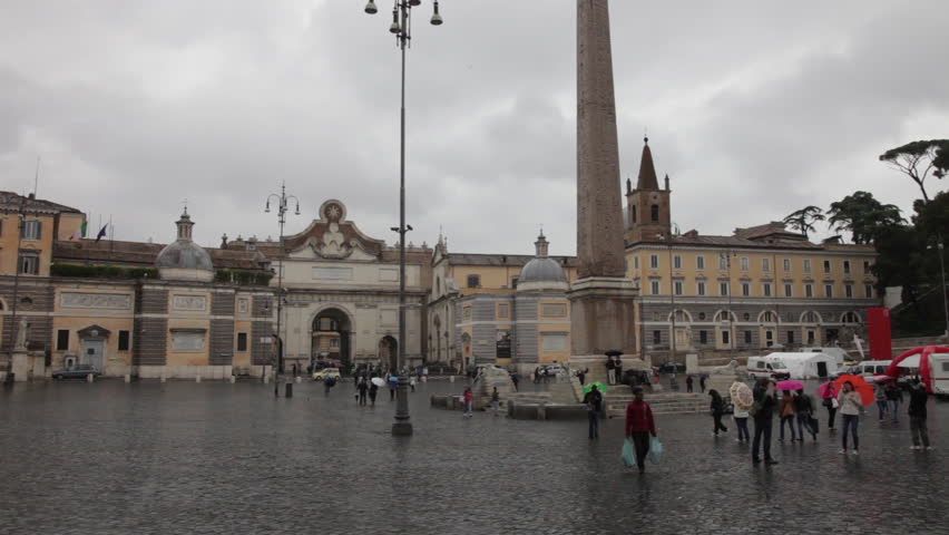 Tourists walking through Piazza del Popolo by egyptian obelisk