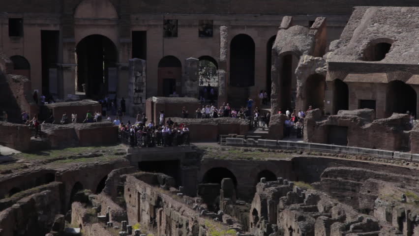 Tourists at the far side of the Colosseum seen from the upper balcony.