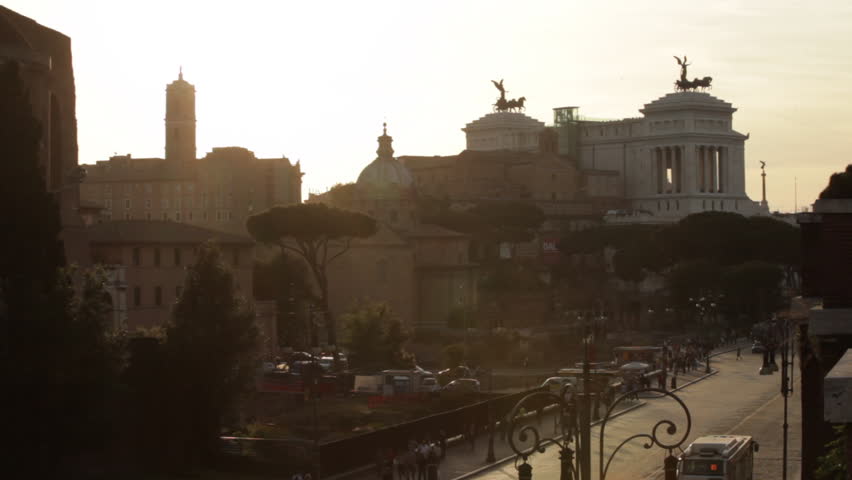 The Vittoriano monument with sunset behind, seen from a park near the Colosseum.