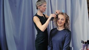 Hairdresser does a hairstyle for a girl