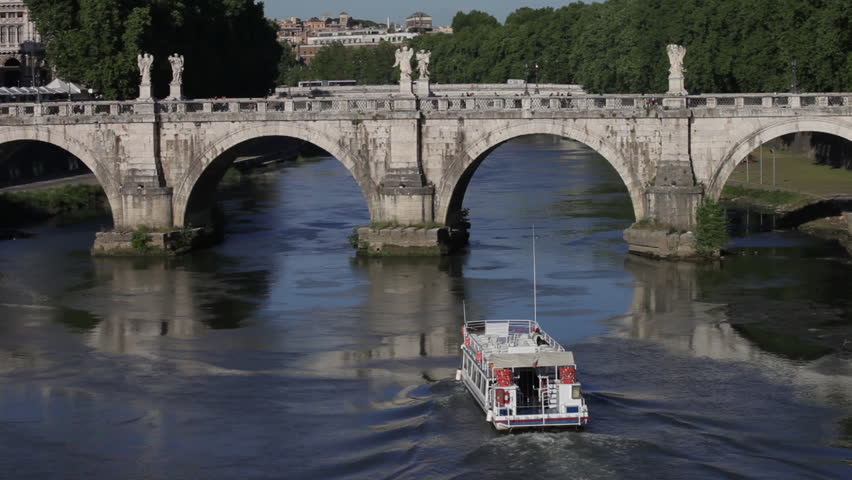 A barge travels on the Tiber, towards and then under the Ponte Sant'Angelo.