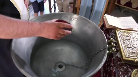 pouring oil in water during christening or baptism