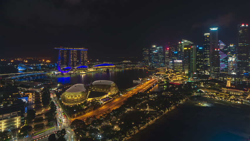 Singapore Beautiful Time lapse at night of Singapore city skyline from aerial and high angle overlooking Marina bay and CBD area. Low light. Tilt up motion timelapse. Prores 4KUHD