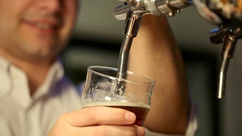 Barman filling a glass of beer in a pub Stock Video