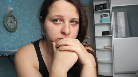 Woman desperate at home. Victim of Abuse Violence. Caucasian girl with long brown hair crying in her room with blue and white. Fat body with overweight. Postpartum Depression