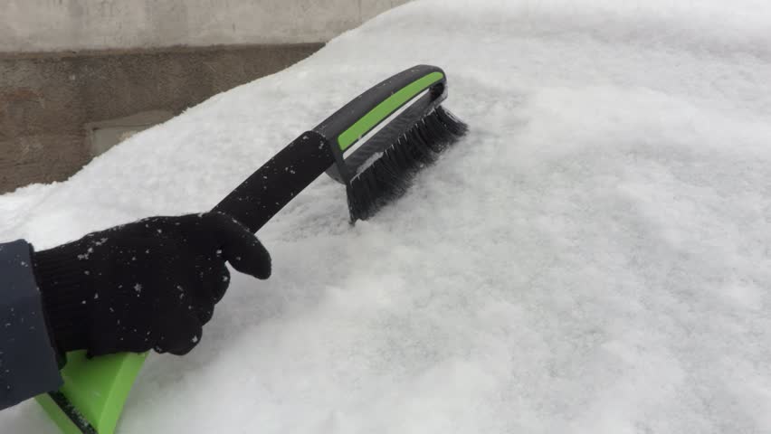 Camera focuses on the  brush near snow covered car
