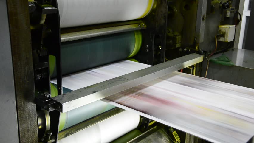 offset print press hit set roll paper goes through the rollers of the printing