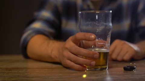 alcohol abuse, drunk driving and people concept - male driver drinking alcoholic beer at home or bar and taking car key from table