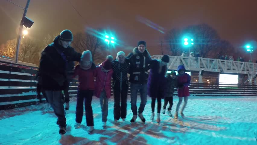 MOSCOW - JUN 15, 2017: Man, woman, two girls and two boys (with model releases) skate in row on ice rink of Gorky Park. During season, ice rink in Gorky Park expects to receive about 1 million people. | Shutterstock HD Video #33844360