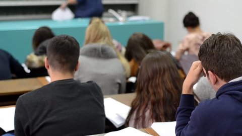 Group of students in a classroom.   Students listening in a lecture hall in University. Education 