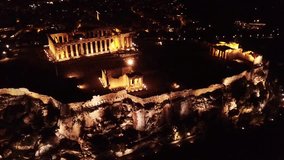 Aerial drone bird's eye night video of iconic Acropolis hill and the Parthenon, Athens historic center, Attica, Greece