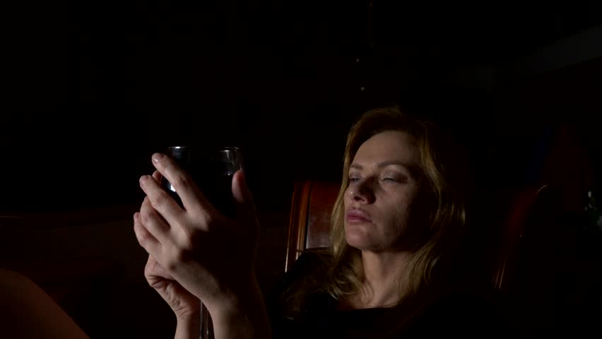 Sad, beautiful woman drinking wine at night. close-up, 4k, slow-motion. | Shutterstock HD Video #33846736