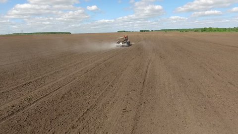 Tractor Spreading Fertilizer on Plowed Field