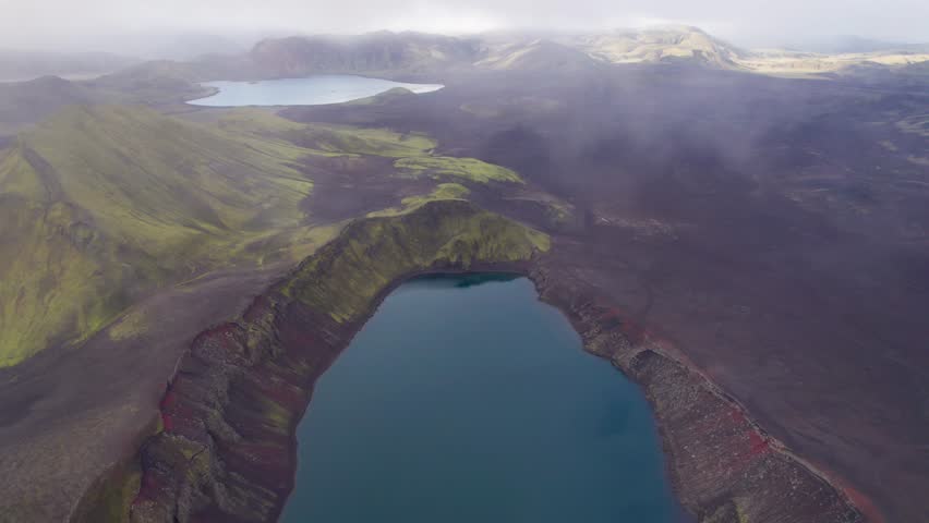 Ljotipollur Crater Lake Beautiful Landscape Drone Epic Wide. Fly Back to Reveal Entire Blue Water Lake, Mountains, Red and Black Lava Sand. 4K High Quality Color Corrected