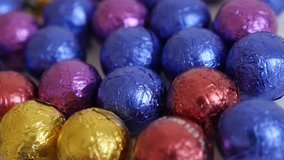 Lot of Christmas chocolate treats wrapped in cellophane slow pan 3840X2160 UltraHD footage - Background with colorful candies close-up 4K 2160p 30fps UHD panning video
