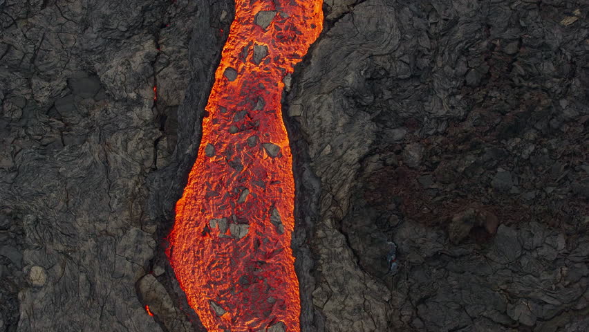 Aerial drone view over river of molten hot lava erupting from the Litli-Hrútur Iceland volcano and flows through dark rock in 2023. Tourist attraction to beautiful and dangerous disaster. Royalty-Free Stock Footage #3385821965