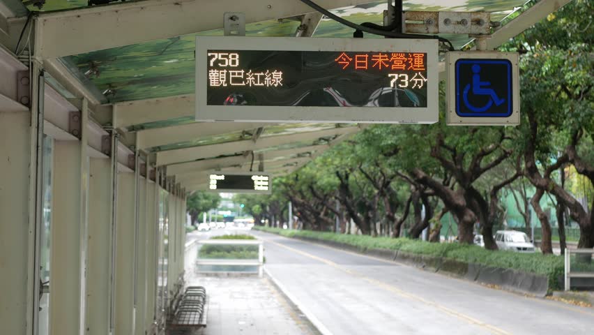 landscape view at bus stop in the city center of Taipei capital city of Taiwan with LED information board for upcomming bus and background empty street in summer daytime.bus stop public transportation