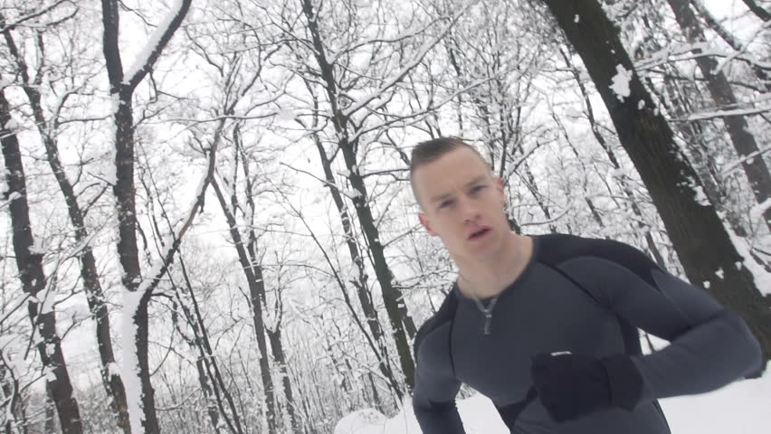 Slow Motion Of Young Sportsman Jogging Outdoors In Snow. Close Shot, Camera