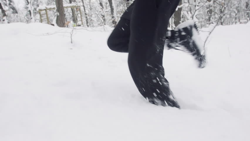 Slow Motion Of Young Sportsman Jogging Outdoors Through Snow 