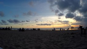 Time Lapse of beach of tropical resort and people recreating in evening summer time.Timelapse of beautiful sunset and night sandy landscape of tropical island with tourists