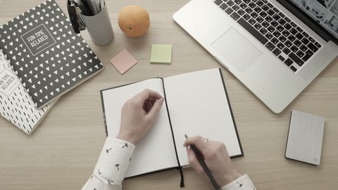 Closeup of young woman's hands sticking adhesive note to a notebook, girl writing tasks and objectives. Healthy lifestyle concept
Office work flatlay. Setting goals. Business woman