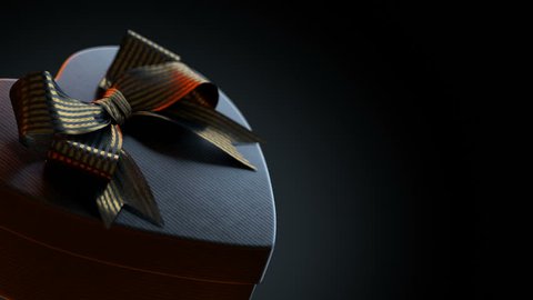 Loopable rotation of black heart shaped gift box with a bow. 3D animation with luma mate.