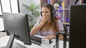 Stunned and scared! young hispanic woman streamer's astonished reaction in gaming room. beautiful face shows shock, disbelief, fear while gaming, headphones on, mouth wide open in amazement. - Powered by Shutterstock - Get 15% off with code: PIKWIZARD15