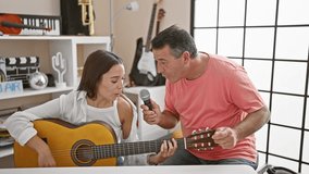 Classic melody in unison, smiling man and woman musicians, confidently playing acoustic guitar, singing soulful song together at spanish music studio - Powered by Shutterstock - Get 15% off with code: PIKWIZARD15