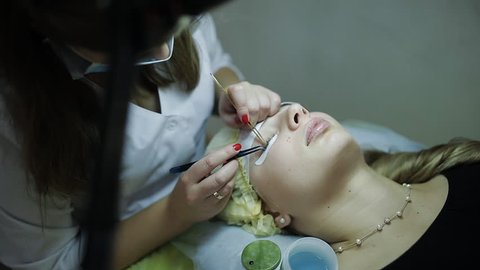 Master lash maker increases eyelashes for young woman