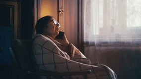 Senior woman wrapped in a blanket calling emergency services, health problems - Powered by Shutterstock - Get 15% off with code: PIKWIZARD15