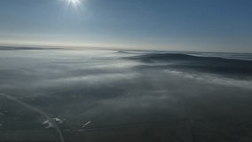 Top down view of agriculture field and forest in summer with morning fog. Footage from a bird's eye view. Cinematic drone shot. Location place Moldova, Europe. Filmed UHD 4k video. Beauty of earth.