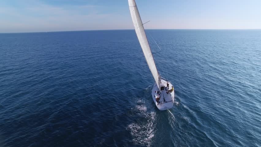 Beautiful epic drone aerial footage on warm sunny day at blue open ocean at sea, white professional yacht during racing competition, full open sails, spinnaker and mainsail at mast Royalty-Free Stock Footage #33880252