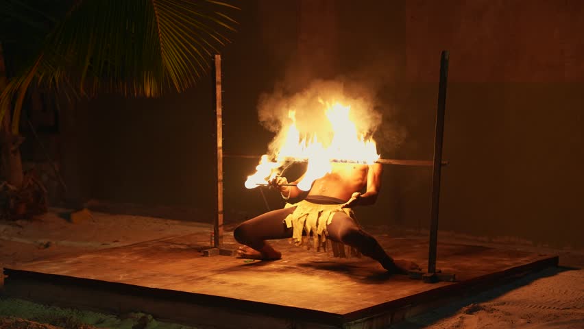 Black Jamaican man performer doing the fire show, fire performance,  fire breathing, firedance and play with fire. Montego Bay, Jamaica. 