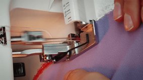 Close up of professional woman tailor sews on sewing machine. Seamstress working and creating hand made dress in tailor's studio. Creation and tailoring clothes. Vertical video
