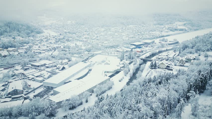 Small village covered with snow at winter. Snowed houses and pine tree forest. Picturesque winter scene with trees, hills and houses. Nature landscape
