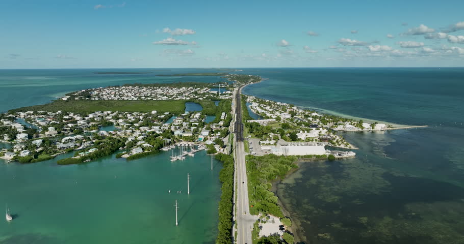 Flying backwards above Florida Overseas highway near Islamorada. Turquoise Atlantic Ocean around the islands 