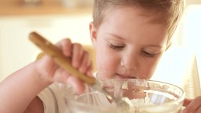 the child does not want to eat porridge. happy family healthy food concept. the boy little son eats porridge with fun a spoon soiled in his face. child dirty eating porridge himself video