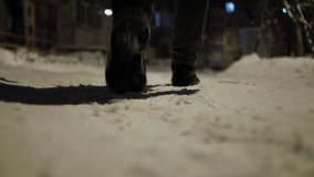winter walks in the snow in the evening. A man in gray pants and black boots walks through the unswept snow on a winter evening under the light of street lamps
a man walks away from the camera  - Powered by Shutterstock - Get 15% off with code: PIKWIZARD15